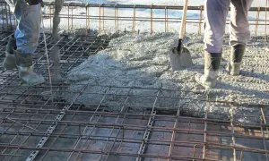 Betonowanie stropu. Widać zbrojenie i wylewaną masę. Trudno oszacować, ile stali na 100m2 stropu, ale praca wre.