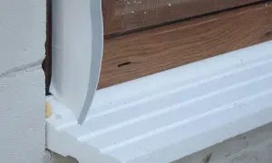 Ciepły parapet po zamontowaniu okna, wykonany ze styropianu, z widoczną taśmą izolacyjną i drewnianą ramą okienną.