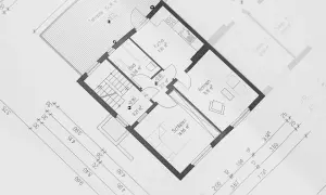 Plan architektoniczny z wymiarami pomieszczeń. Pokazuje, jak liczyć powierzchnię użytkową domu, uwzględniając kuchnię, łazienkę, sypialnie i salon.