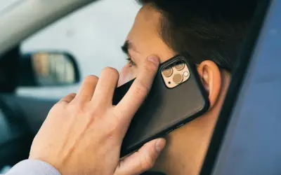 Mężczyzna w samochodzie rozmawia przez telefon. Czy bank dzwoni do klienta?