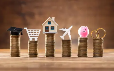 Stosy monet symbolizują cele życiowe: edukację, zakupy, dom, podróże, oszczędności i małżeństwo. Limit odnawialny a debet – jak zarządzać finansami?