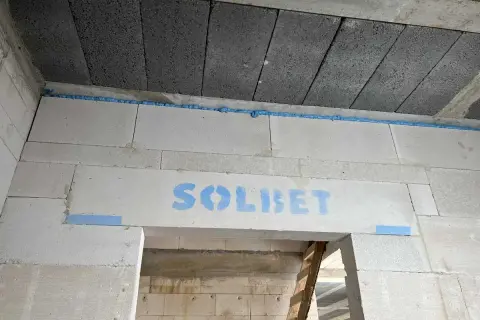 Dylatacja betonu na budowie, widoczna niebieska pianka montażowa i logo SOLBET na nadprożu.