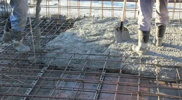 Betonowanie stropu. Widać zbrojenie i wylewaną masę. Trudno oszacować, ile stali na 100m2 stropu, ale praca wre.