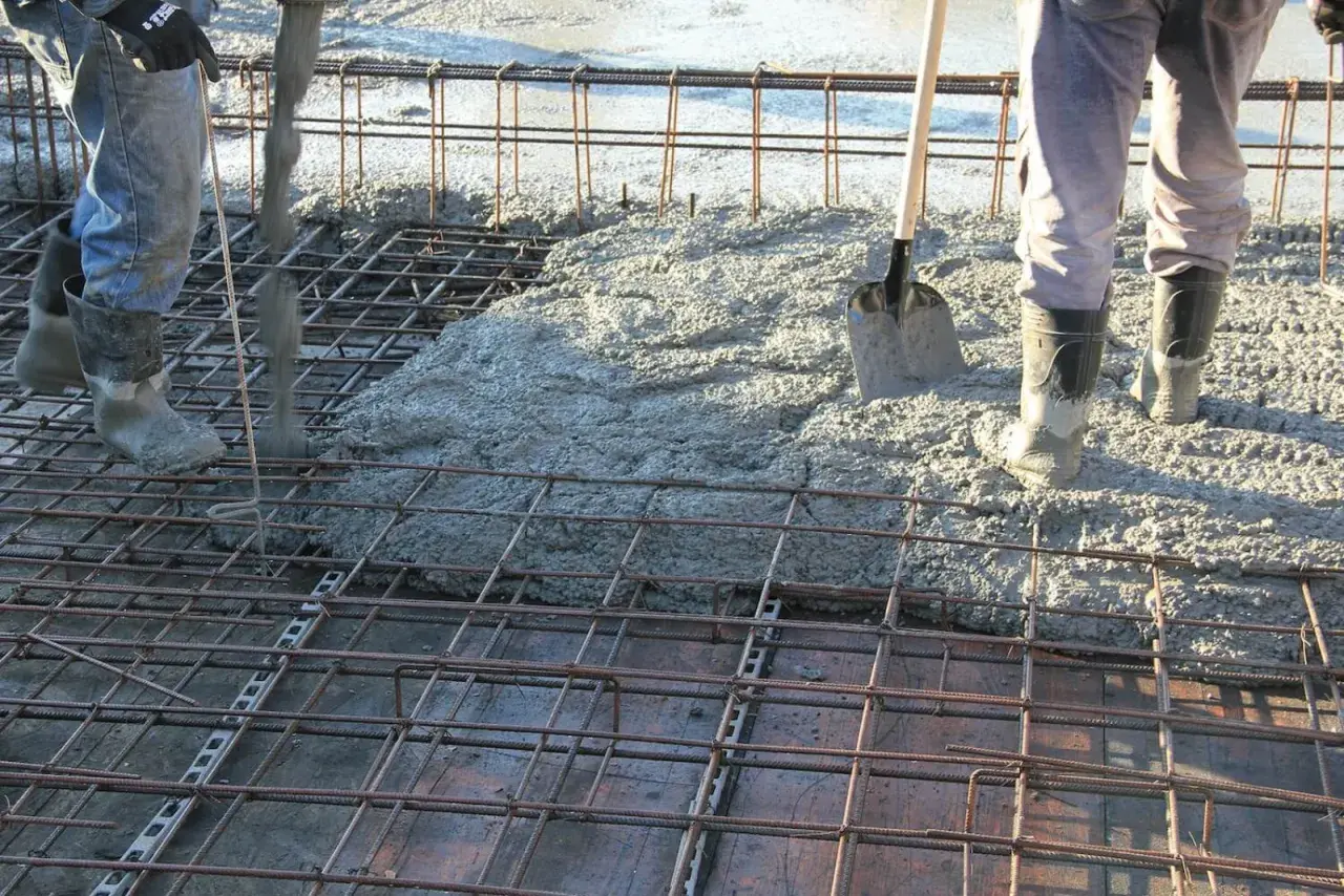 Betonowanie stropu. Widać zbrojenie i wylewaną masę. Trudno oszacować, ile stali na 100m2 stropu, ale praca wre.