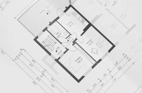 Plan architektoniczny z wymiarami pomieszczeń. Pokazuje, jak liczyć powierzchnię użytkową domu, uwzględniając kuchnię, łazienkę, sypialnie i salon.
